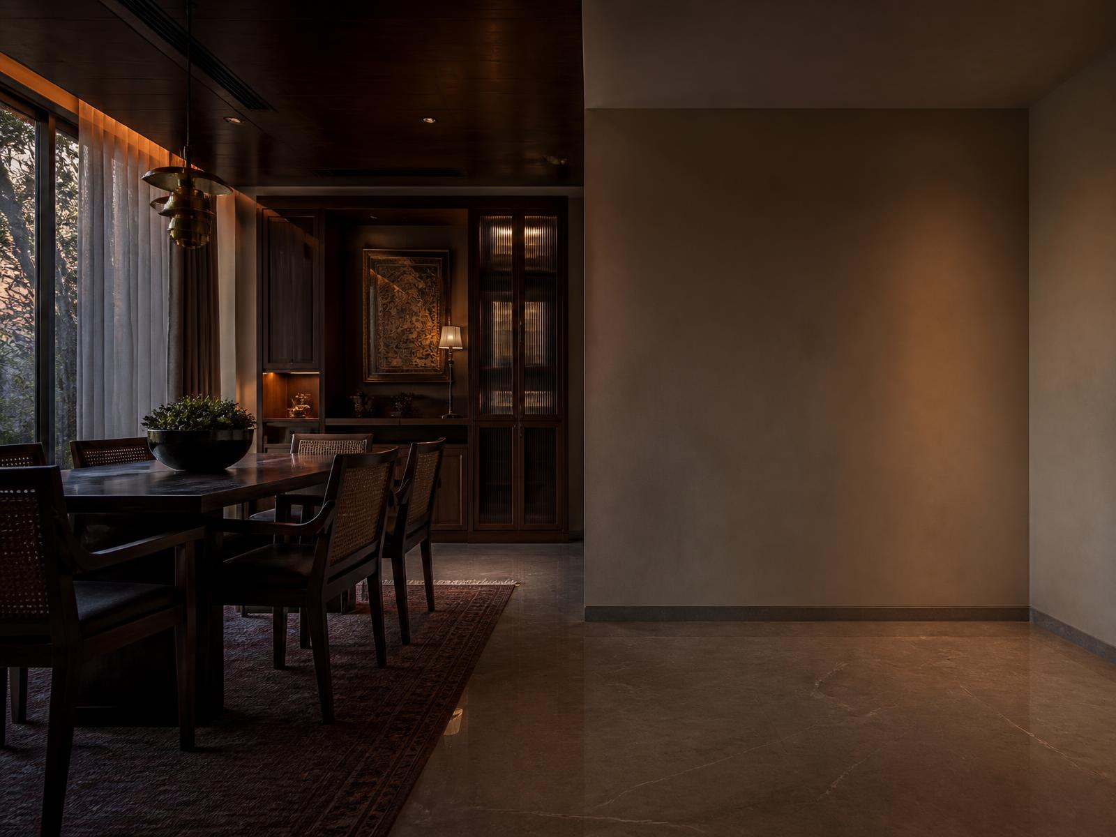 Warm-toned dining room in a premium Indian home with an empty full-height wall