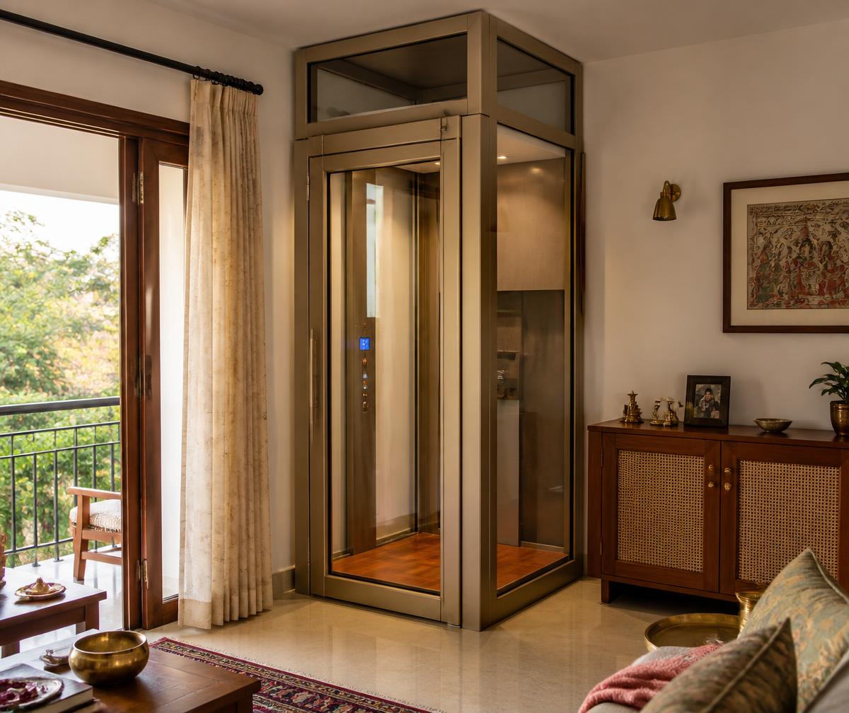 Glass home lift tucked into the corner of a family sitting room with cane joinery and warm daylight